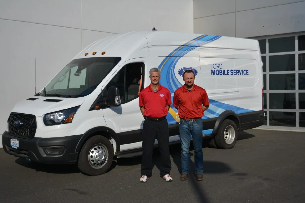 Two men standing in front of Wendle Ford Mobile Service van.